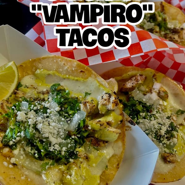 Two Blacktop Grill Vampiro Tacos with chicken, cheese, cilantro, onions, and lime in a paper tray.